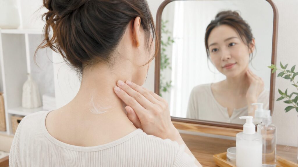 うなじ脱毛後に保湿剤で首の後ろをケアする日本人女性